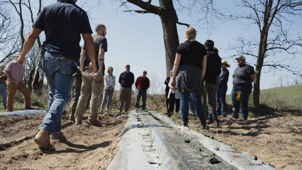 Group of people talking at farm